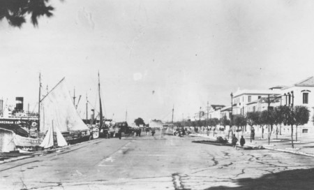 Ιστιοφόρα και φορτηγά στο λιμάνι, δεξιά η Ναυαρίνου